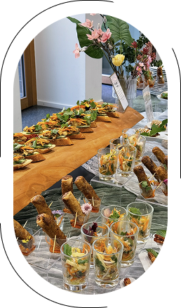 Ein Buffet mit verschiedenen schmackhaften Häppchen und dekorativen Blumenarrangements.